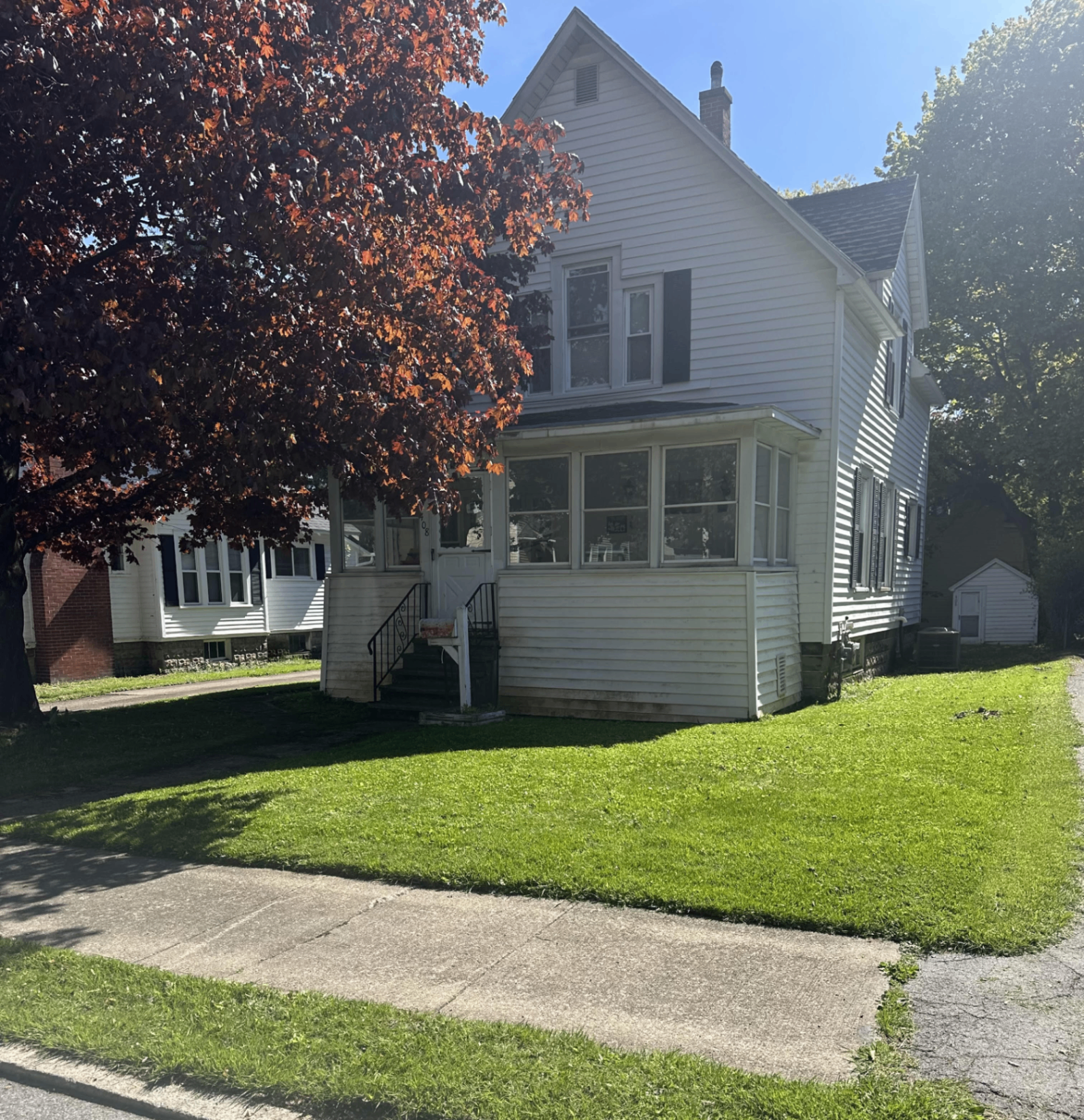 Freshly mowed front lawn with crisp mowing stripes in front of a charming home